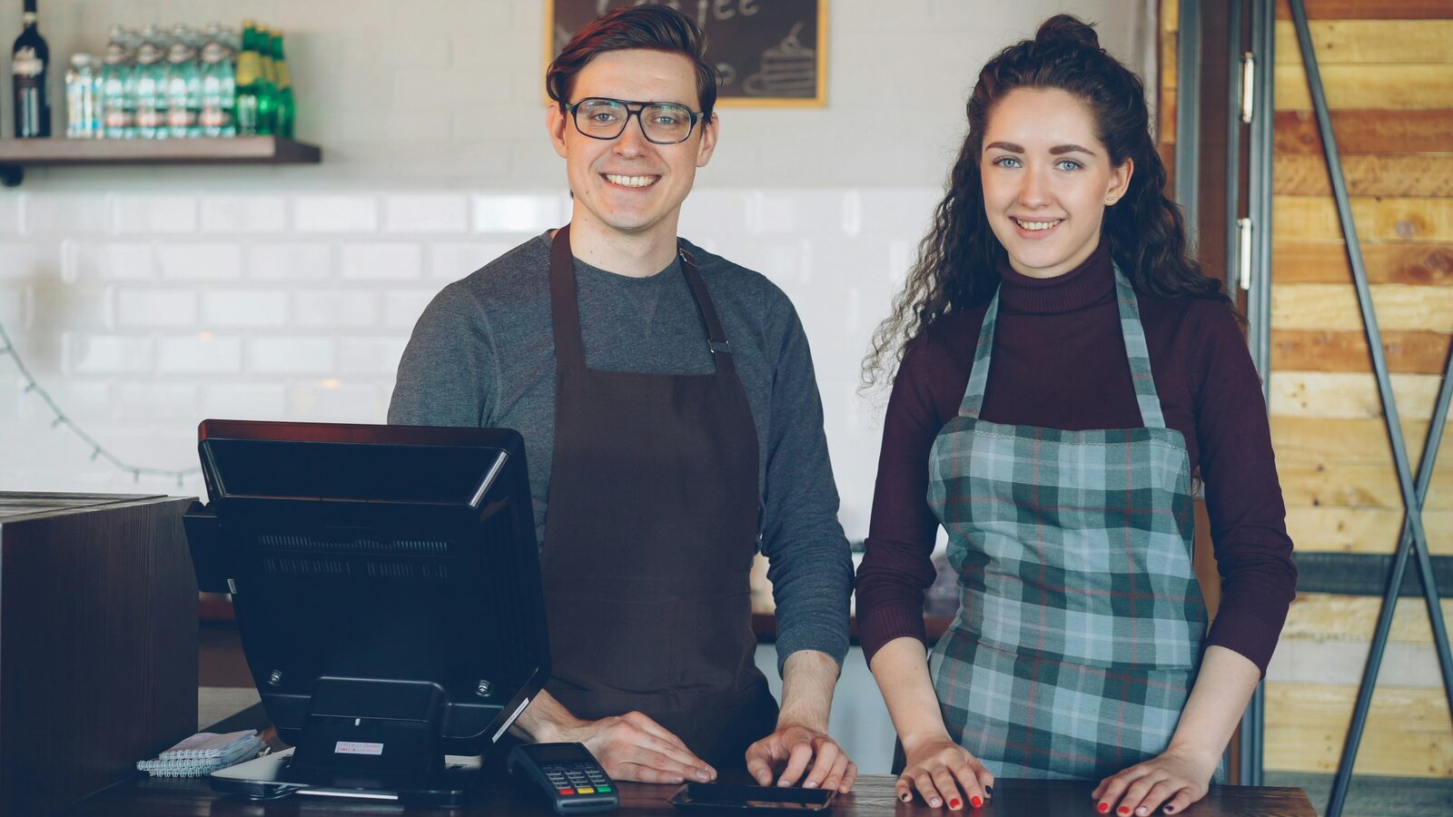 Two confident small-business owners at their counter